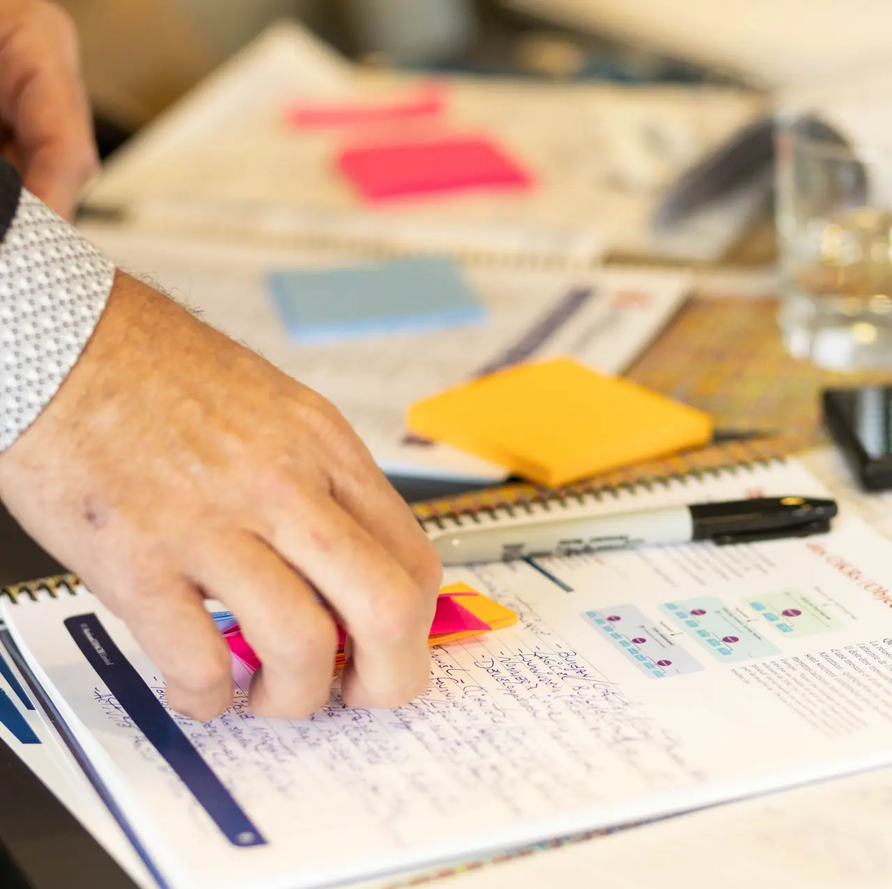 Un participant annote son cahier d’exercices avec des notes adhésives