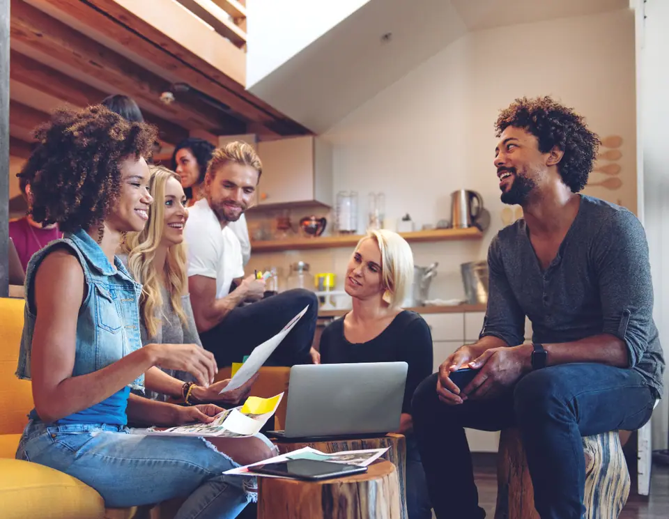Un groupe d'entrepreneurs échange autour de documents et d'un ordinateur portable